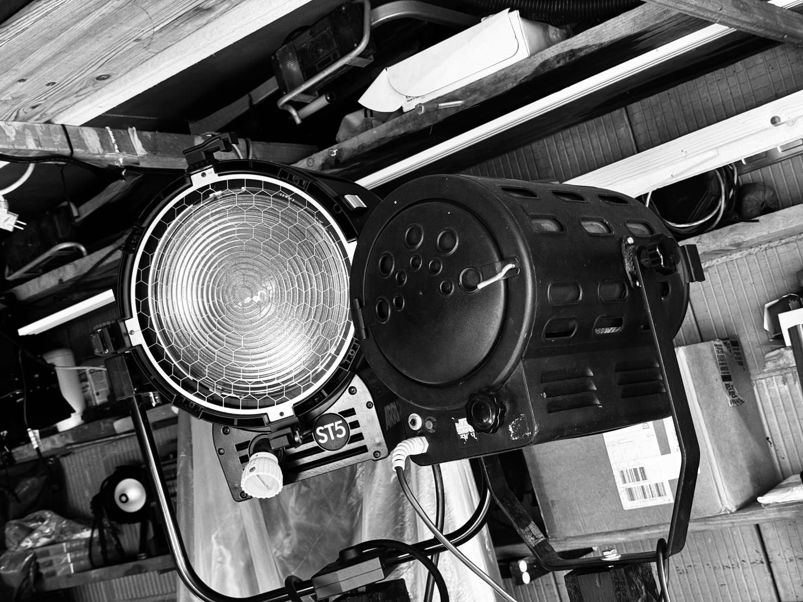 An ARRI ST5 fresnel lamp and a second lamp mounted in the workshop, in black and white.